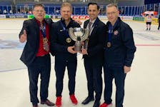 Head coach Gardiner MacDougall, left, of Bedeque, P.E.I., and Hockey Canada’s manager of medical services Kevin Elliott, right, of Charlottetown join assistant coach Travis Crickard, second right, and equipment manager A.J. Murley for a photo with the International Ice Hockey Federation world under-18 male hockey championship trophy. Team Canada defeated the United States 6-4 in the gold-medal game in Espoo, Finland, on May 4. Crickard, head coach of the Quebec Maritimes Junior Hockey League’s Saint John Sea Dogs, and Murley are from St. John’s. Gardiner MacDougall • Special to The Guardian