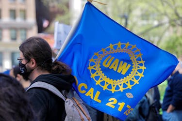 A person carries a flag with the patch from the United Auto Workers (UAW) labor union during a May Day rally for media workers held by The NewsGuild of New York on International Workers' Day in Manhattan, New York City, New York, U.S., May 1, 2021.