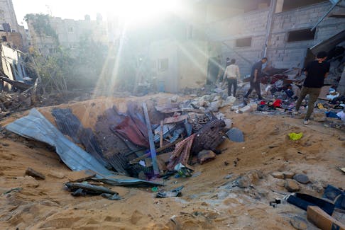 Palestinians inspect the site of an Israeli strike on a house, amid the ongoing conflict between Israel and the Palestinian Islamist group Hamas, in Rafah, in the southern Gaza Strip, May 8, 2024.