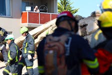 A resident watches as rescuers work to rescue construction workers trapped under a building that collapsed in George, South Africa May 8, 2024.