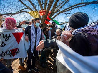 A woman is made to leave the area of an anti-Israel encampment in an area that was fenced off at the University of Toronto campus in downtown Toronto on May 2, 2024. 