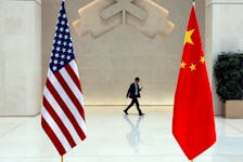 A man walks past U.S. and Chinese flags on the day of a meeting between U.S. Treasury Secretary Janet Yellen and People's Bank of China (PBOC) Governor Pan Gongsheng, in Beijing, China April 8, 2024.