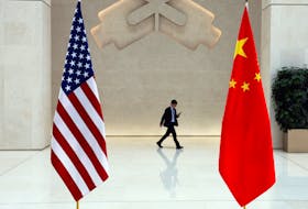 A man walks past U.S. and Chinese flags on the day of a meeting between U.S. Treasury Secretary Janet Yellen and People's Bank of China (PBOC) Governor Pan Gongsheng, in Beijing, China April 8, 2024.