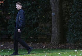 Barron Trump, son of U.S. President Donald Trump, walks to the Marine One helicopter with his parents as they depart for travel to Florida from the South Lawn of the White House in Washington, U.S., November 26, 2019.