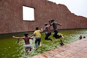 Children jump into the water body of Martyred Intellectuals Memorial at Rayerbazar to cool themselves during a heatwave in Dhaka, Bangladesh, April 23, 2024. REUTERS/Mohammad Ponir Hossain