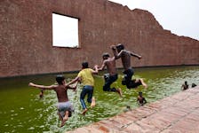 Children jump into the water body of Martyred Intellectuals Memorial at Rayerbazar to cool themselves during a heatwave in Dhaka, Bangladesh, April 23, 2024. REUTERS/Mohammad Ponir Hossain