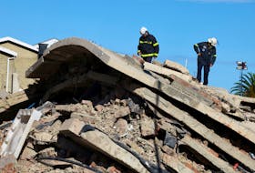 Rescuers work to rescue construction workers trapped under a building that collapsed in George, South Africa May 8, 2024.