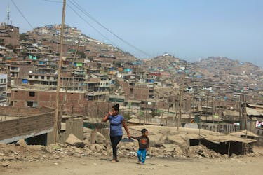 A woman and child walk on the hills  of Villa Maria del Triunfo, a shanty town on the outskirts of Lima, Peru May 9, 2017. Picture taken May 9, 2017.