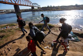 Migrants walk along the banks of the Rio Grande river before crossing in an attempt to seek asylum into the U. S., as seen from Piedras Negras, Mexico September 29, 2023.