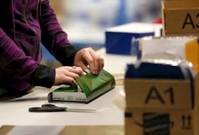 A worker gift wraps a holiday order for a customer at the Amazon Fulfillment Center in Tracy, California, November 29, 2015.