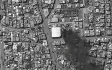 A black-and-whte satellite image shows smoke rising from a building and an overview of Rafah, amid the ongoing conflict between Israel and the Palestinian Islamist group Hamas, in the southern Gaza Strip, May 7, 2024. The picture was originally black and white from the source. Maxar Technologies/Handout via REUTERS