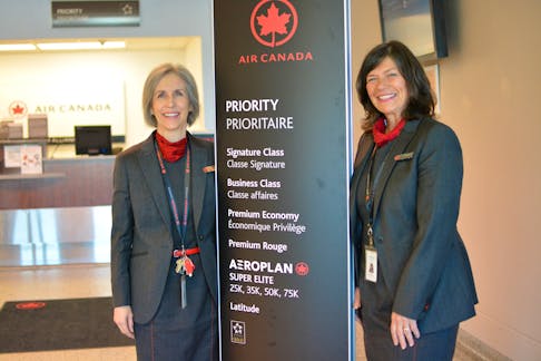 Clare MacDougall, left, and Leslie MacArthur stand next to a priority boarding sign for Air Canada Jazz at the J.A. Douglas McCurdy airport on Tuesday, where they have worked for 35 years. NICOLE SULLIVAN/CAPE BRETON POST