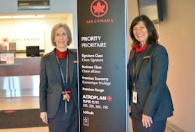 Clare MacDougall, left, and Leslie MacArthur stand next to a priority boarding sign for Air Canada Jazz at the J.A. Douglas McCurdy airport on Tuesday, where they have worked for 35 years. NICOLE SULLIVAN/CAPE BRETON POST