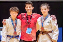 Coach Matt MacGrath, centre, congratulates Island judokas Hikaru Wells, left, and Keely MacGrath on winning bronze medals at the recent 2024 Canadian Open national judo championships in Montreal.