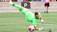 A diving Yann Fillion of the Halifax Wanderers can't stop Atletico Ottawa's Ollie Bassett shot in the 84th minute of a Sunday afternoon match in Ottawa. - Canadian Premier League