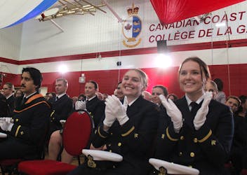 Canadian Coast Guard College graduates Grace Hall (centre) and Kiersten Power cheer on a classmate crossing the stage during their graduation ceremony on Saturday. Thirty-seven officers were officially made coast guards, as graduates of the Westmount institution's four-year program. LUKE DYMENT/CAPE BRETON POST