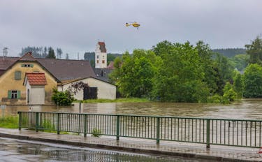 A rescuer hangs from an emergency helicopter of Germany’s automobile club ADAC as people are rescued from the floods of the river Schmutter following heavy rainfalls in Fischach, south of the city of Augsburg, Germany, June 1, 2024.  Vifogra/Tobias Hartl via