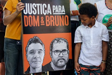 A boy looks at a placard during a demonstration one year after Phillips and Brazilian Indigenous issues expert, Bruno Pereira, were killed in the Amazon, in Copacabana beach in Rio de Janeiro, Brazil June 5, 2023.