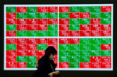 A passerby walks past Japan's Nikkei stock prices quotation board outside a brokerage in Tokyo, Japan February 19, 2024.