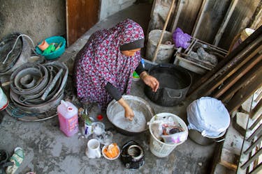Displaced Palestinian woman Umm Muhammad Khrouat washes kitchen items at a school she returned to with her family, after the school was badly damaged in an Israeli raid, in Jabalia refugee camp in the northern Gaza Strip, June 2, 2024.