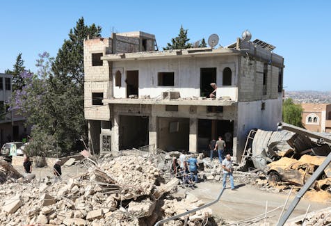 People inspect a damaged building amid ongoing cross-border hostilities between Hezbollah and Israeli forces in Houla village near the border with Israel, southern Lebanon, June 3, 2024.