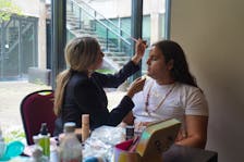 Nelly Jadis, an esthetician, is preparing Mattie Comeau, a model from New Brunswick, to walk the runway at a fashion show event held at the Confederation Centre of Art on June 1. The event is part of the 2024 Petapan, to celebrate Indigenous artists. Vivian Ulinwa/SaltWire