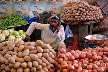 A man selling vegetables waits for customers at his makeshift stall at the Empress Market in Karachi, Pakistan April 2, 2018.
