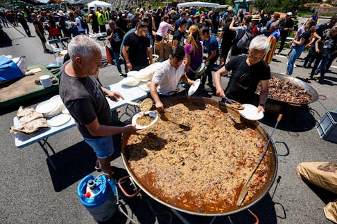 People prepare food as farmers with tractors block the highway AP-7, near the border between Spain and France, during a demonstration demanding better conditions ahead European elections, in Le Perthus, Spain, June 3, 2024.