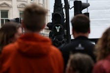 FILE PHOTO:A transgender symbol is displayed on a traffic light while people walk across a pedestrian crossing in Trafalgar Square in London, Britain, April 10, 2024.