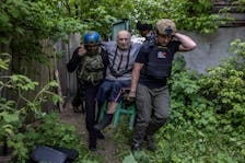 Ukrainian Police evacuate an elderly resident from the town of Kozacha Lopan on the Russian border in the northern Kharkiv region of Ukraine, May 18, 2024. As Moscow’s forces retake land from which they were ousted at the end of 2022, the Ukrainian military has adopted a strategy of fighting while slowly falling back to more heavily fortified positions. (Finbarr O’Reilly/The New York Times)  Ukrainian Police evacuate an elderly resident from the town of Kozacha Lopan on the Russian border in the northern Kharkiv region of Ukraine, May 18, 2024. As Moscow’s forces retake land from which they were ousted at the end of 2022, the Ukrainian military has adopted a strategy of fighting while slowly falling back to more heavily fortified positions.