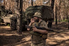 A member of Ukraine’s 45th Brigade smokes near a Swedish-supplied Archer 155mm wheeled self-propelled howitzer in Ukraine’s northeastern Kharkiv Region, Monday, June 3, 2024.