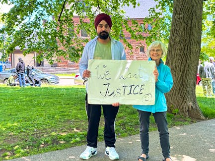 Harmandeep Singh and Mary Cowper-Smith are among more than 200 people who gathered at a rally outside the George Coles Building in Charlottetown on June 6. This is part of a protest ongoing since early May in opposition to the recent changes to P.E.I.’s immigration policy. Thinh Nguyen • The Guardian