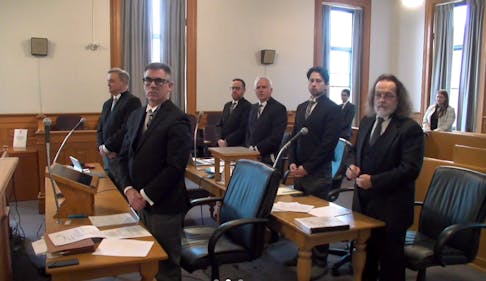 Lawyers involved in the Roman Catholic Episcopal Corporation's insolvency and its settlement of abuse claims stand as Newfoundland and Labrador Supreme Court Justice Garrett Handrigan, attending by video, begins proceedings Thursday, June 6, 2024.
