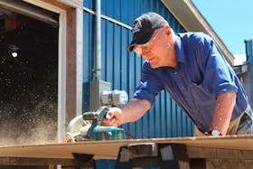 Murdock MacLeod of Cape North cuts a sheet of plywood in two while building a mini shed on Thursday. The founder and once-owner of Cabot Building Supplies, the 91-year-old continues to build more than two dozen sheds every year as passion projects — an achievement which locals say is only part of the legend he's built around himself over the years. LUKE DYMENT/CAPE BRETON POST
