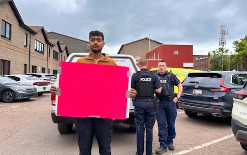 Organizer Rupinder Pal Singh holds a sign that reads, "King, do the right thing" on June 7. He said he and other protesters were told they could come into the P.E.I. office of immigration in Charlottetown to discuss their options to remain in Canada with officials. Although police were called to the building that day, as of early afternoon, none of the protestors had been detained. Vivian Ulinwa • SaltWire