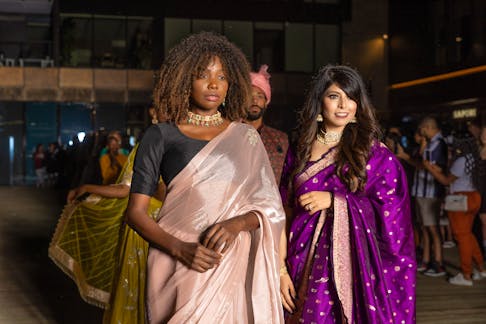 Sudha and Solitha pose in Southeast Asian clothes at a fashion show