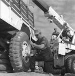 A Canadian peacekeeper changes the tire of a United Nations transport truck in the Golan Heights in 1974. Government of Canada • Department of National Defence ME74-177
