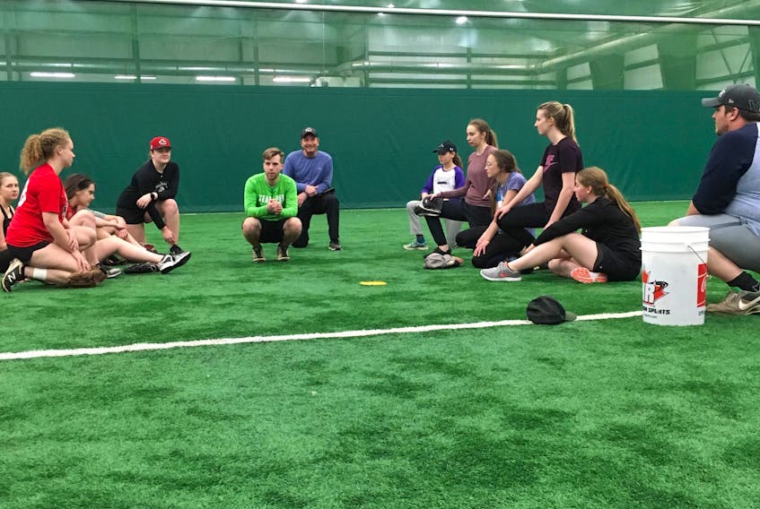 Head coach Randy Byrne, centre, speaks to the players on Team P.E.I. for this week’s 16-and-under girls’ national baseball championship in Bedford, N.S., during a training session in Stratford.