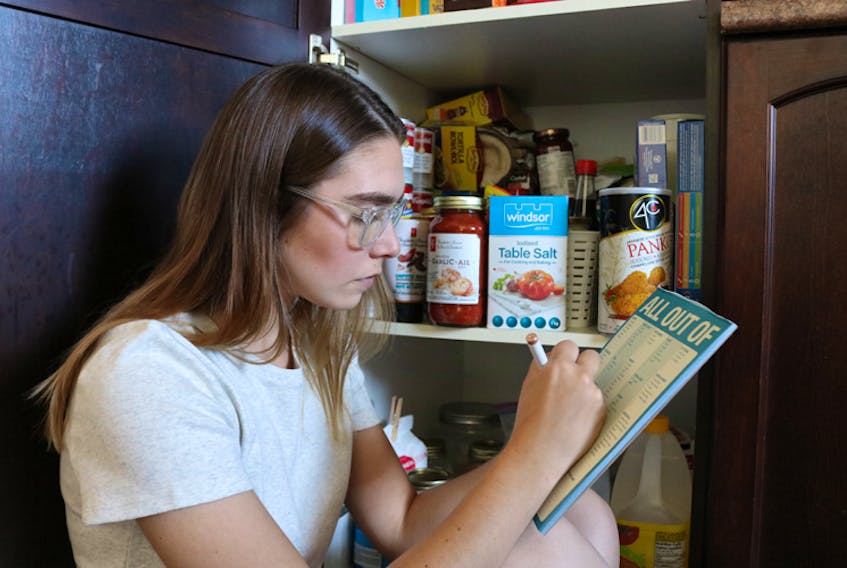 Millennial Homemaker Millee surveys her fridge and cabinets before making her grocery list.