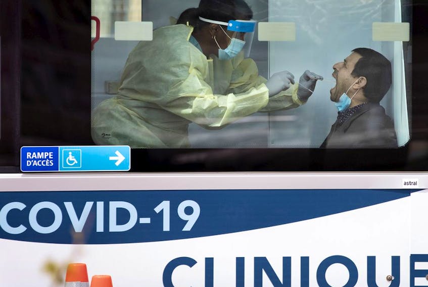 A health-care worker administers a test swab at a mobile COVID-19 testing site in Montreal on May 9, 2020.