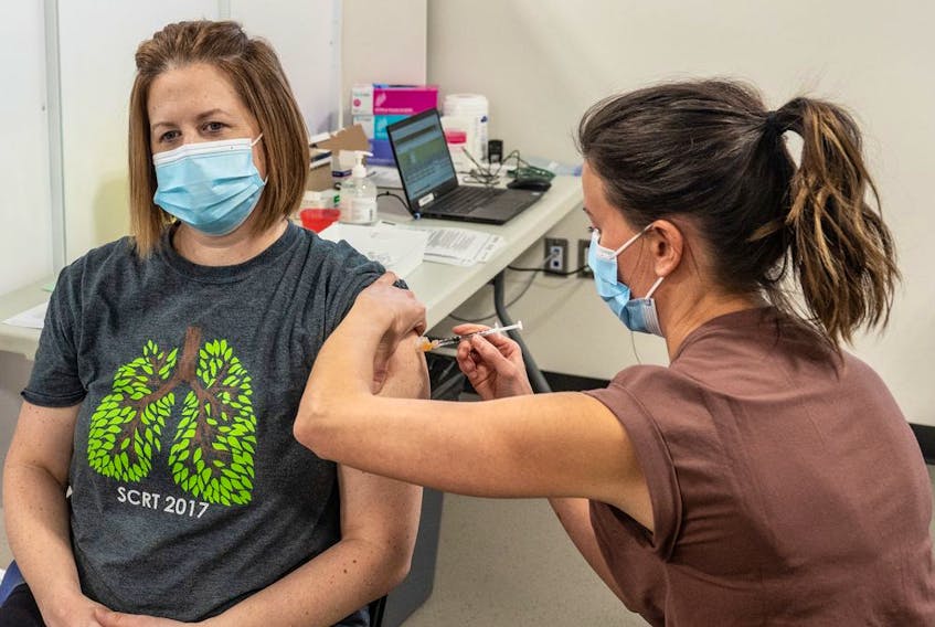 Respiratory therapist Karen Schmid receives the Pfizer Covid-19 vaccine from registered nurse Lianne Korte, becoming the first person in Saskatoon to receive the vaccine. Photo taken in Saskatoon, SK on Tuesday, December 22, 2020.