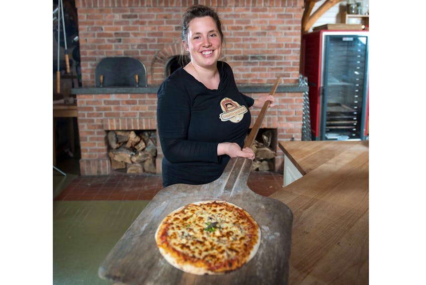 Bonavista Social Club owner Katie Hayes with a pizza just out of the wood-fired oven.
