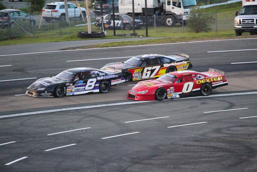 Kent Vincent leads Dylan Blenkorn, Car 67, and Shawn Turple through the turn Saturday at Scotia Speeworld during the Toromont 250. – Pat Healey photo