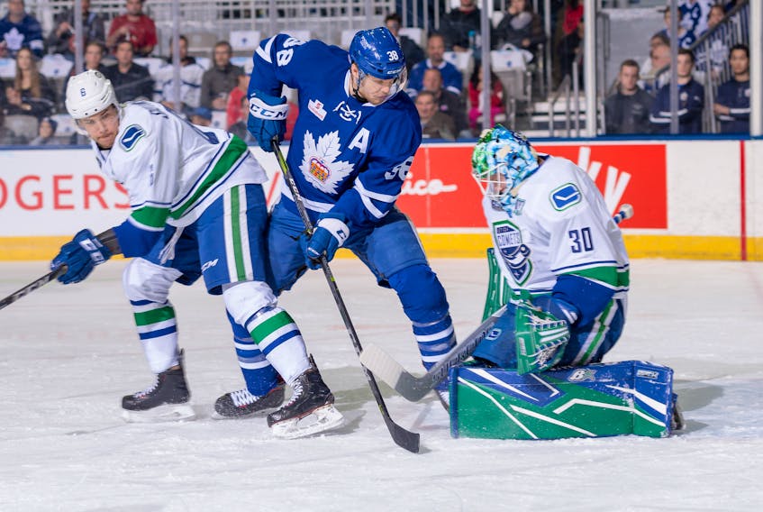 Toronto Marlies forward Colin Greening (38) tries to jam the puck behind Utica Comets goaltender Thatcher Demko as Utica defeneman Ashton Sautner (6) looks on during Game 5 of their first-round American Hockey League playoff series Sunday in Toronto. The Marlies won 4-0 take the best-of-series and advance to the second round of the Calder Cup playdowns, where they are taking on the Syracuse Crunch. Greening, a 32-year-old from St. John's, averaged a point per game in the first round. — Toronto Marlies photo