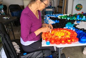 Anne Camozzi works in her painting studio in her Antigonish home. Camozzi, who has a progressive neurological disease, says the pandemic has put a spotlight on what she calls a broken home-care system.