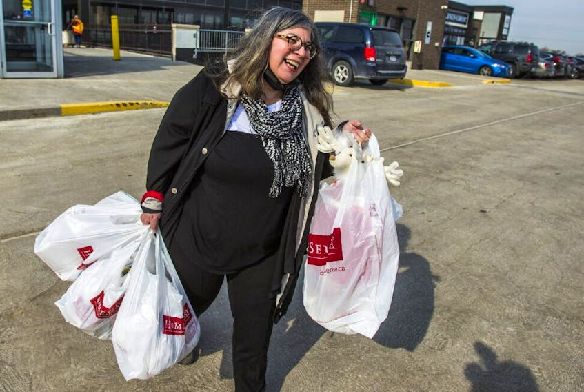 Rita DeMontis, the  Sun's senior national lifestyle and food editor, carries her haul to her car after  enjoying in-store shopping at the HomeSense at Stock Yards Village in Toronto, on March 8, 2021. 
