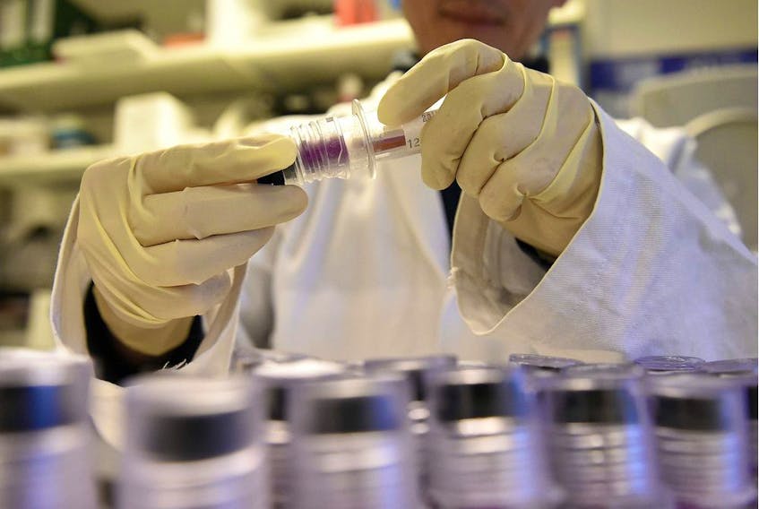 (FILES) This file photo taken on December 15, 2015 shows a technician holding blood samples about to be tested at the French national anti-doping laboratory, in Chatenay-Malabry, outside Paris.  