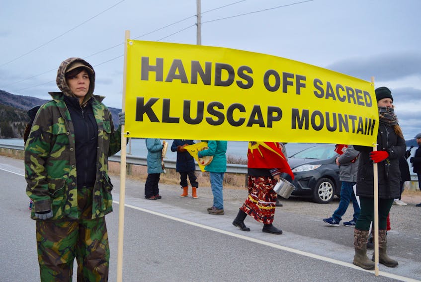 Steph Paul, left, and Jay Rawding hold a banner reading “Hands off sacred – Kluscap Mountain” during a rally against mining on the mountain and other protected areas in the province on Saturday. Close to 40 attended the rally, which took place near the Seal Island Bridge in Victoria County. Jeremy Fraser/Cape Breton Post