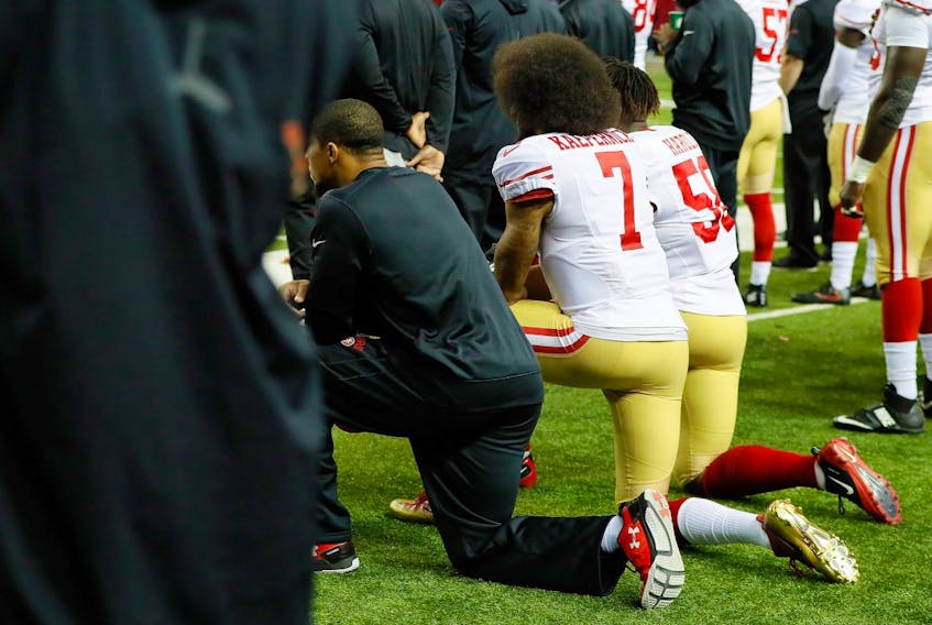  Colin Kaepernick #7 of the San Francisco 49ers and Eli Harold #58 kneel during the National Anthem prior to the game against the Atlanta Falcons at the Georgia Dome on December 18, 2016 in Atlanta, Georgia.