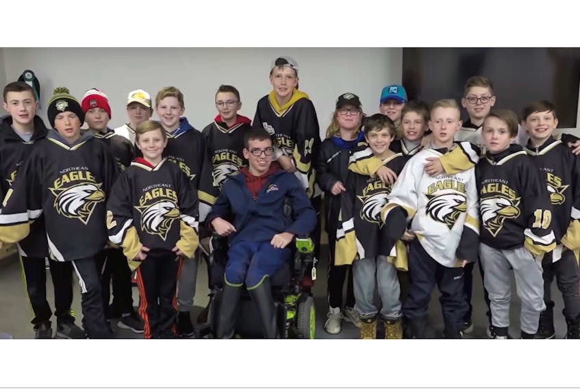 Members of the Northeast Eagles peewee C hockey team gather around Rainbow Riders client Nathan Chaulk, who is the older brother of Eagles netminder Sam Chaulk (directly behind his brother). The Eagles’ fundraising on behalf of Rainbow Riders has made them a regional finalist in the national Chevrolet Good Deeds Cup competition. — YouTube